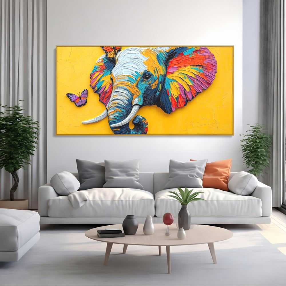 Tablou canvas cu tablou canvas cu elefant colorat si fluturi, in rama de aluminiu auriu, pe perete intr-un living